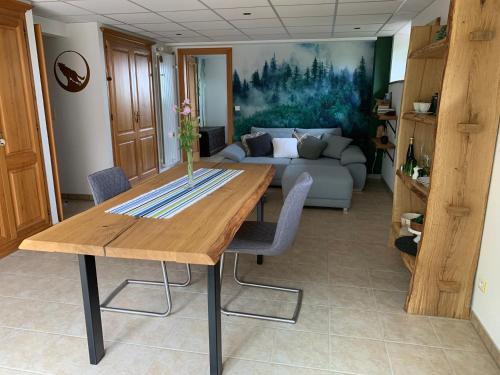 a living room with a wooden table and a couch at Éco-Gîte "La Chouette Verte" - Eco-Lodge "The Green Owl" in Wangenbourg
