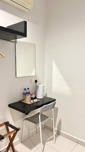 a black table with a chair in a room at Melody Inn Hotel in Kluang