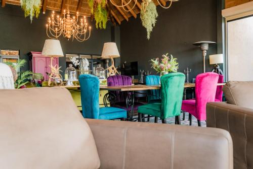 a dining room with a table and colorful chairs at SW1 Lodge in Somerset West