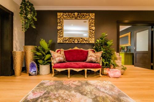 a living room with a red couch and a mirror at SW1 Lodge in Somerset West