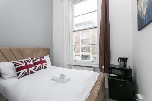 een slaapkamer met een bed met een hoed erop bij Rooms In Yorkway - KC17 in Londen