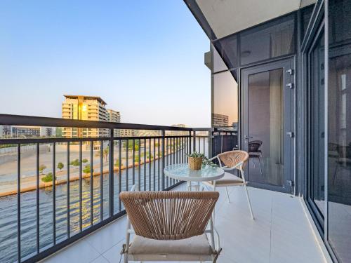 a balcony with a table and chairs and a view at Fantastic Rooftop Pool - Full Canal Views - Spacious 1 BDR Designed by Designer - 5 min walk from Space42 Arena in Abu Dhabi