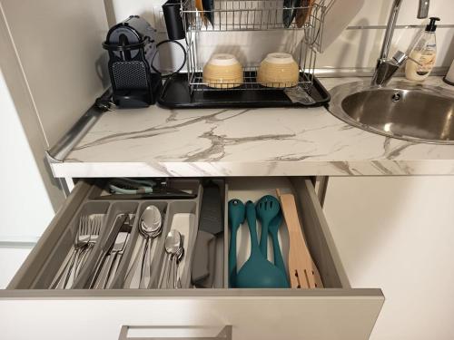 eine Küchenschublade mit Utensilien und einer Spüle in der Unterkunft Casa Blanca - Alameda in Toledo
