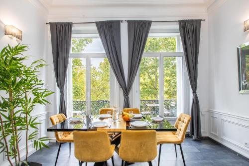 ein Esszimmer mit Tisch und Stühlen und einem Fenster in der Unterkunft Pyramide in Mulhouse