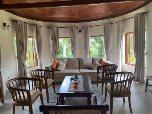 a living room with a couch and a table and chairs at Sarangu VIlla in Akuressa