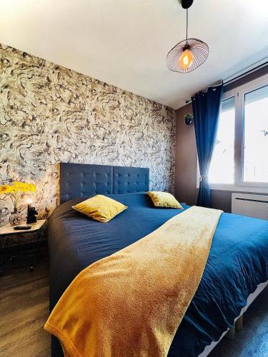 a bedroom with a bed with a blue bedspread at Maison des Sens in Saint-Omer