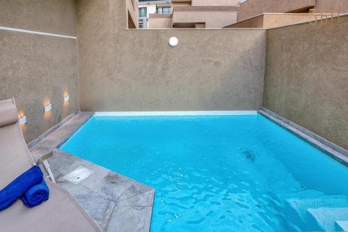 a large swimming pool in a room with at The Pender LUX HUB - 4BR villas with Pool, WIFI & AC by 360 Estates in St Julian's