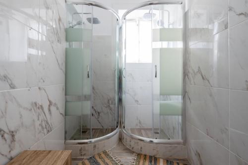 a bathroom with two mirrors and a shower at Quinta das Virtudes in Funchal