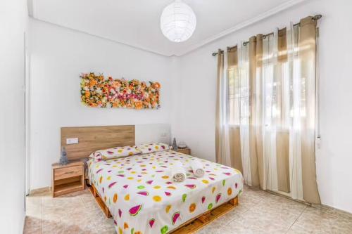a bedroom with a bed and a painting on the wall at Ground floor apartment with terrace and pool in La Mata