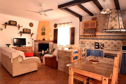 eine Küche und ein Wohnzimmer mit einer Couch und einem Tisch in der Unterkunft Caminito Del Rey Valley House in Valle de Abdalagís