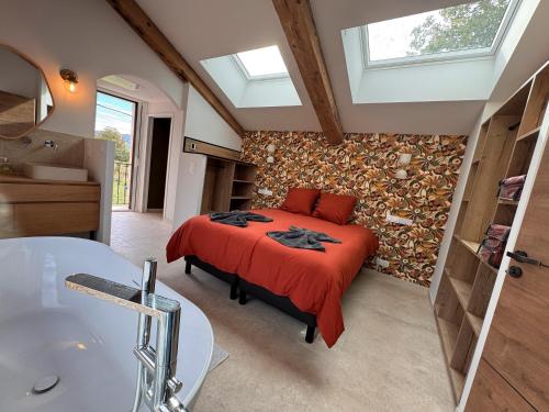 a bedroom with a bed and a bathroom with a tub at La Master Grange De Queyran in La Palud sur Verdon