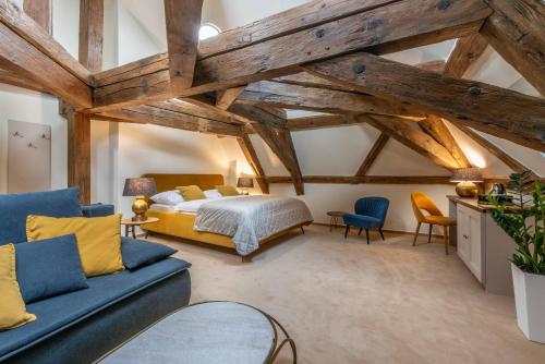 a bedroom with a king sized bed and a blue couch at Zámecký hotel & Wellness in Poděbrady