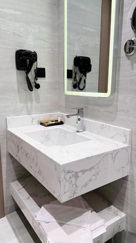 a white sink in a bathroom with a mirror at البرج للشقق المخدومة 2 in Al Nairyah