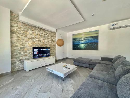 a living room with a couch and a tv at Grand Amber Villa in Diani Beach