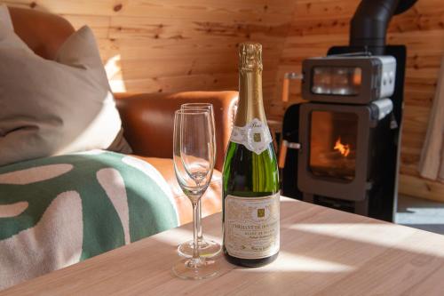 a bottle of champagne and a wine glass on a table at The Hygge Out - Glamping Site in North Yorkshire in Ebberston