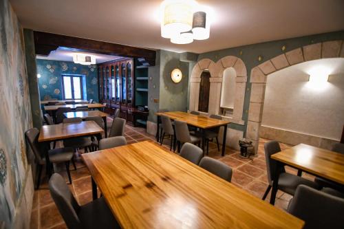 a restaurant with wooden tables and chairs and a clock at La Cachava in Castrojeriz