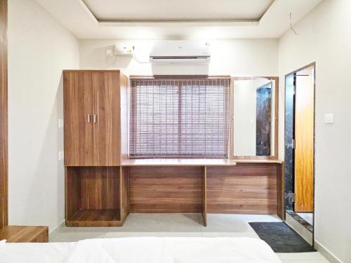 a bedroom with a window and a wooden cabinet at The Urban Escape in Udupi