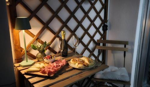 Una mesa con un plato de comida y una botella de vino. en UM81 - Downtown Apartment, en Trieste