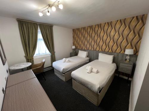 a hotel room with two beds and a window at Ox Hotel Carlisle in Carlisle