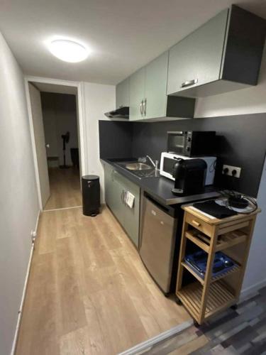 a small kitchen with a counter and a microwave at Appartement Peronne Centre in Péronne