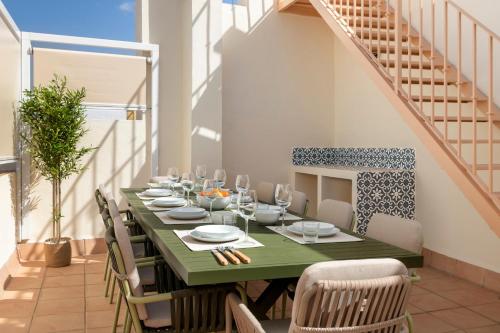 a dining room with a green table and chairs at Casa 1872, by Homing U in Seville