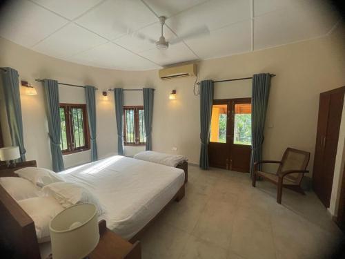 a bedroom with two beds and a chair at Sarangu VIlla in Akuressa