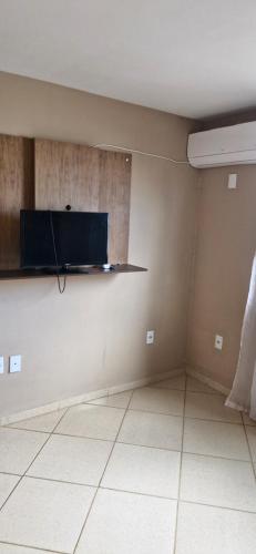 an empty room with a tv on a wall at Casa da Jussara in Itaperuna