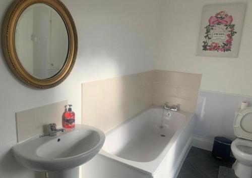ein Badezimmer mit Badewanne, Waschbecken und Spiegel in der Unterkunft A&A Luxury Stay Tunstall in Sunderland