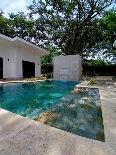 a swimming pool with blue water in front of a house at Le MaGil Boutique Hotel in Tamarindo