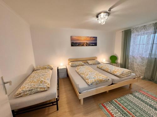a bedroom with two beds and a chandelier at Ferienwohnung Kity mit Terrasse und Bergblick in Grainau