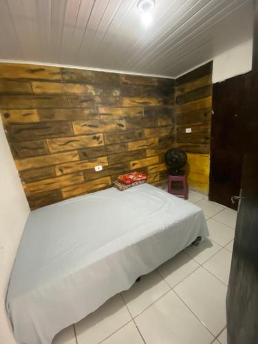 a bedroom with a bed with a wooden wall at Alugo casa festival de inverno in Garanhuns