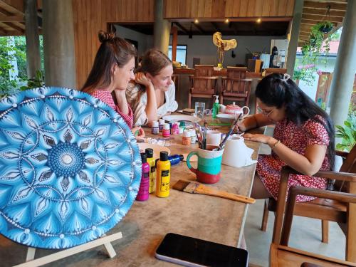 three women sitting at a table with a blue plate at Bokka Almeida in Hikkaduwa