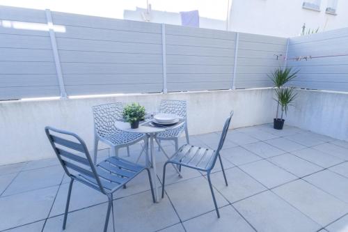 ein Tisch und Stühle auf einer Terrasse in der Unterkunft Cosy de la Pointe Rouge - Terrasse - Port plage et commerces in Marseille