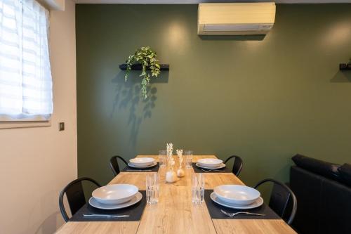 einem Holztisch mit Tellern und Geschirr darauf in der Unterkunft Cosy de la Pointe Rouge - Terrasse - Port plage et commerces in Marseille