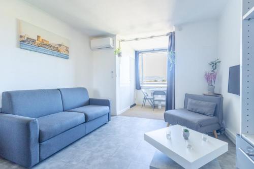 La Baie des Anges - Plage à Pied - Garage Privé في لاسيوتا: غرفة معيشة مع أريكة زرقاء وطاولة