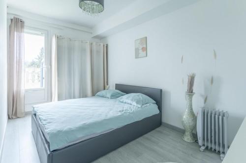 een witte slaapkamer met een bed en een raam bij Appartement T3 Allauch - Jardin calme - Cocon d'allauch in Allauch