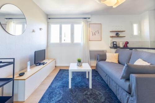 ein Wohnzimmer mit Sofa und Tisch in der Unterkunft Magnifique T2 - Centre Sanary & Parking privé - Senaya in Sanary-sur-Mer