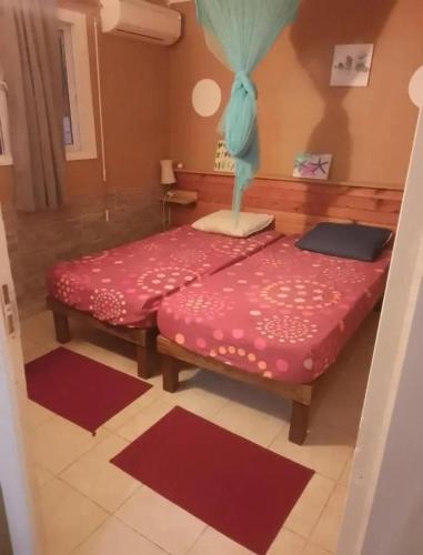 two beds in a room with mats on the floor at Appartement avec Terrasse à Capesterre-Belle-Eau in Petites Mamelles