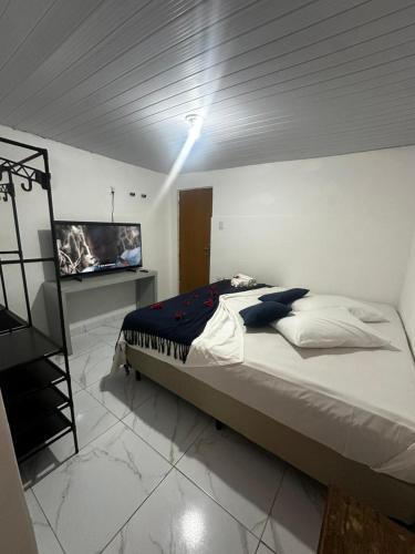 a bedroom with a bed and a television in it at Pousada Dois Irmãos in Fernando de Noronha