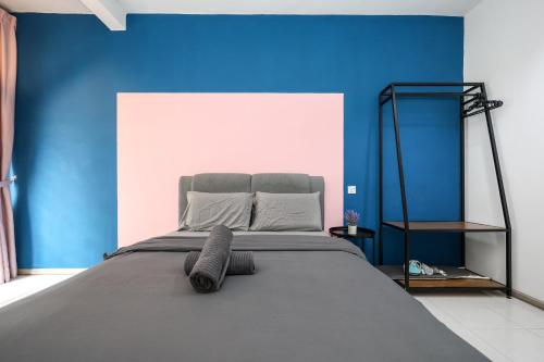 une chambre avec un grand lit avec un mur bleu dans l'établissement FAMILY Unit Emerald Avenue 5-06, à Brinchang