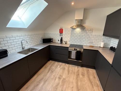 eine Küche mit Spüle und Herd in der Unterkunft Penthouse 2 bed 1 bathroom property in centre in Abingdon