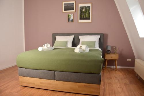 a bedroom with a large bed with two towels at Maisonette-Apartment für bis zu 6 Personen - Parkplatz - WLAN - Kingsize in Berlin