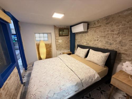 a bedroom with a bed and a stone wall at Loft Cosy Stone House in Konak