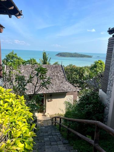 a house with a staircase leading to the ocean at Sea top room in Amphoe Koh Samui