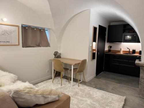 a living room with a table and a kitchen at Chalet La Landonne chaleureux pour 2 in La Combe