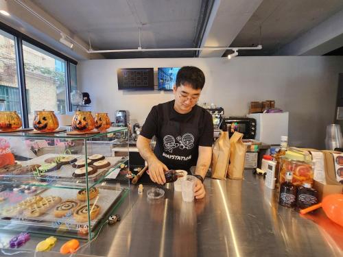 ein Mann steht hinter einer Theke in einer Küche in der Unterkunft Suwon Stay 111 in Hagwanggyo-dong