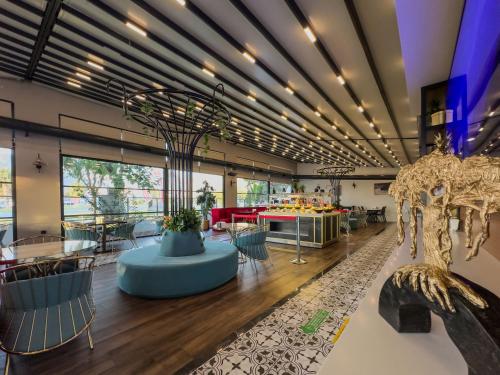 アンタルヤにあるLeaf Port Hotelのテーブルと椅子が備わる広い客室とロビー