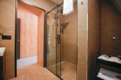 a shower with a glass door in a bathroom at Golf Forest Creek Villas in Zavidovići