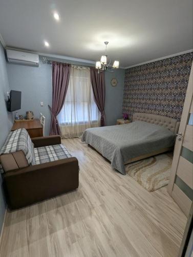 a bedroom with a bed and a couch at Villa Maria in Novoarkhanhel's'k
