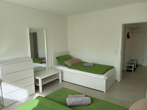 two beds in a white room with green sheets at Ferienwohnung Eyb in Ansbach